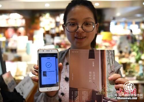 资料图：读者展示自己借阅的书籍。 <a target=