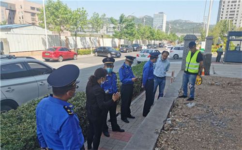 青岛崂山：工地围挡超占人行道 执法人员责令整改
